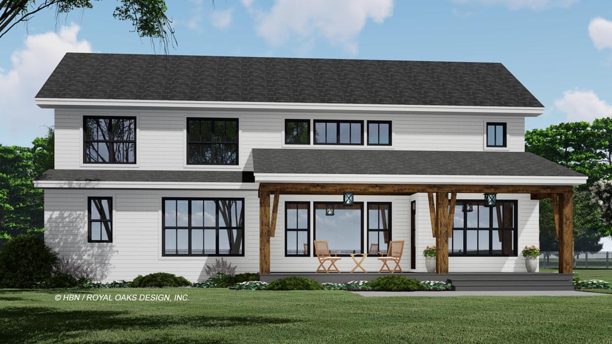 A modern two-story white house with black-framed windows and a covered porch supported by large wooden beams, set on a green lawn.