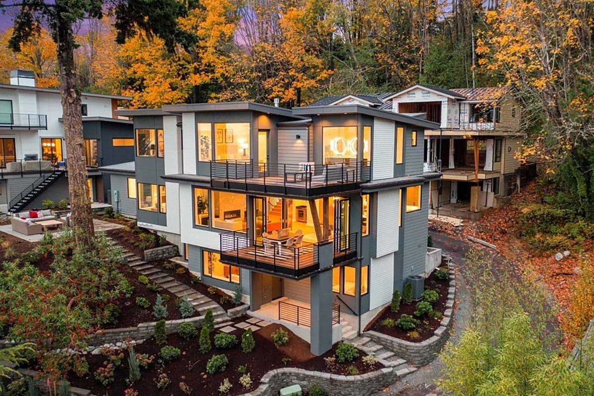 Modern house plan exterior with multiple balconies, large windows, and layered levels on a sloped lot.