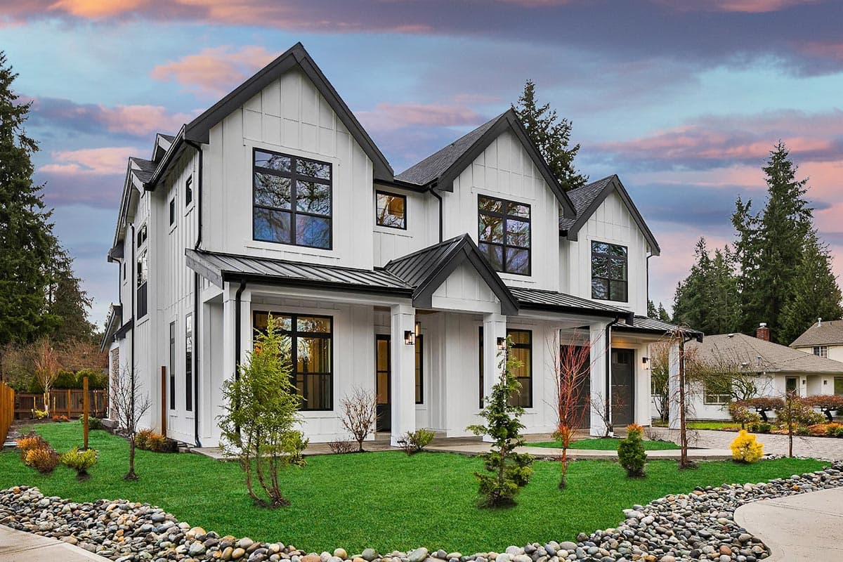 Modern Farmhouse style house plan exterior with white vertical siding, black gable roofs, and prominent porch.