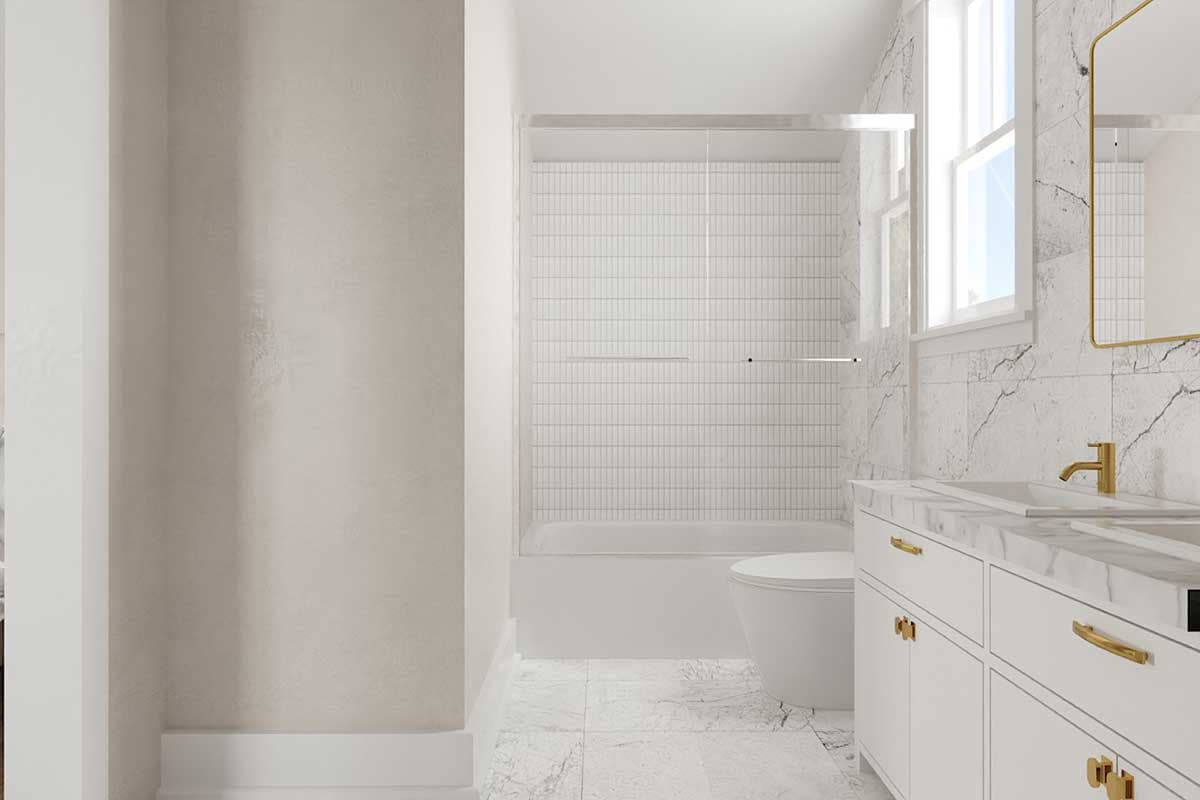 Bathroom with white subway tile shower surround, freestanding tub, double vanity with marble countertop, and gold fixtures.