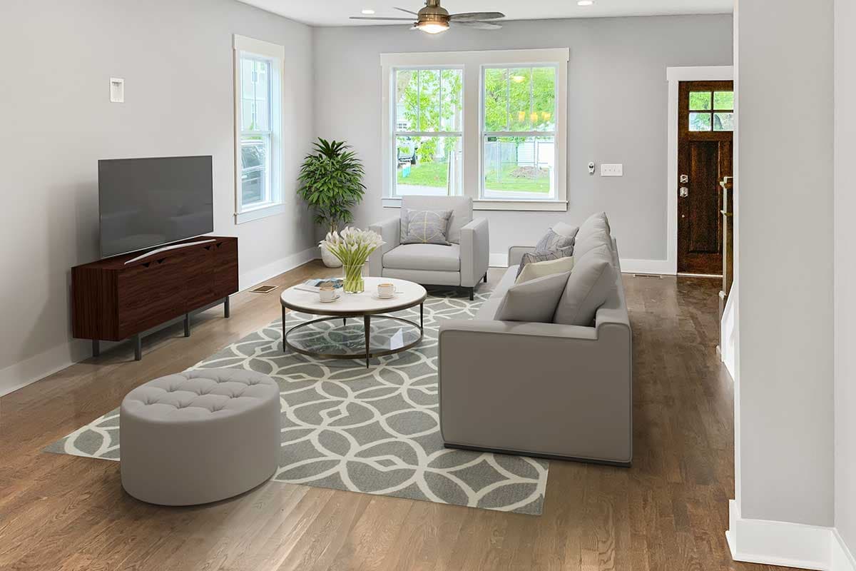 Living room with sofa, armchairs, coffee table, ottoman, TV, and wooden door.
