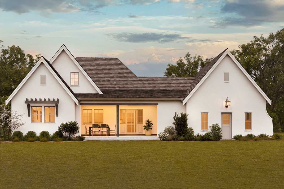 House plan exterior with gabled rooflines, a covered patio with outdoor dining, and stucco walls.