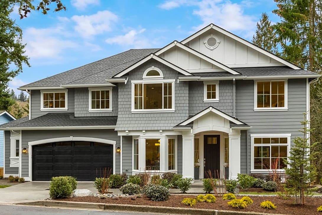 House plan exterior. Two-story home with a gabled roof, dormers, and a front-facing garage. Features a covered entry porch with columns.