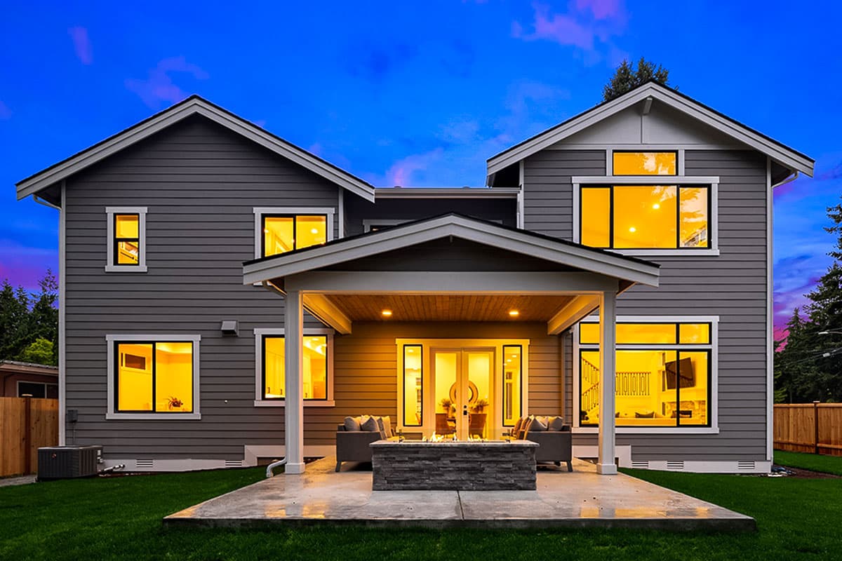 Exterior house plan: Two-story Modern style with gable roof, covered patio with fire pit, and numerous large windows.