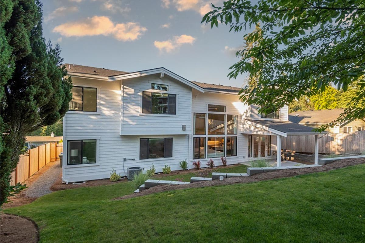 Modern house plan exterior with white siding, multi-story design, and large picture windows.