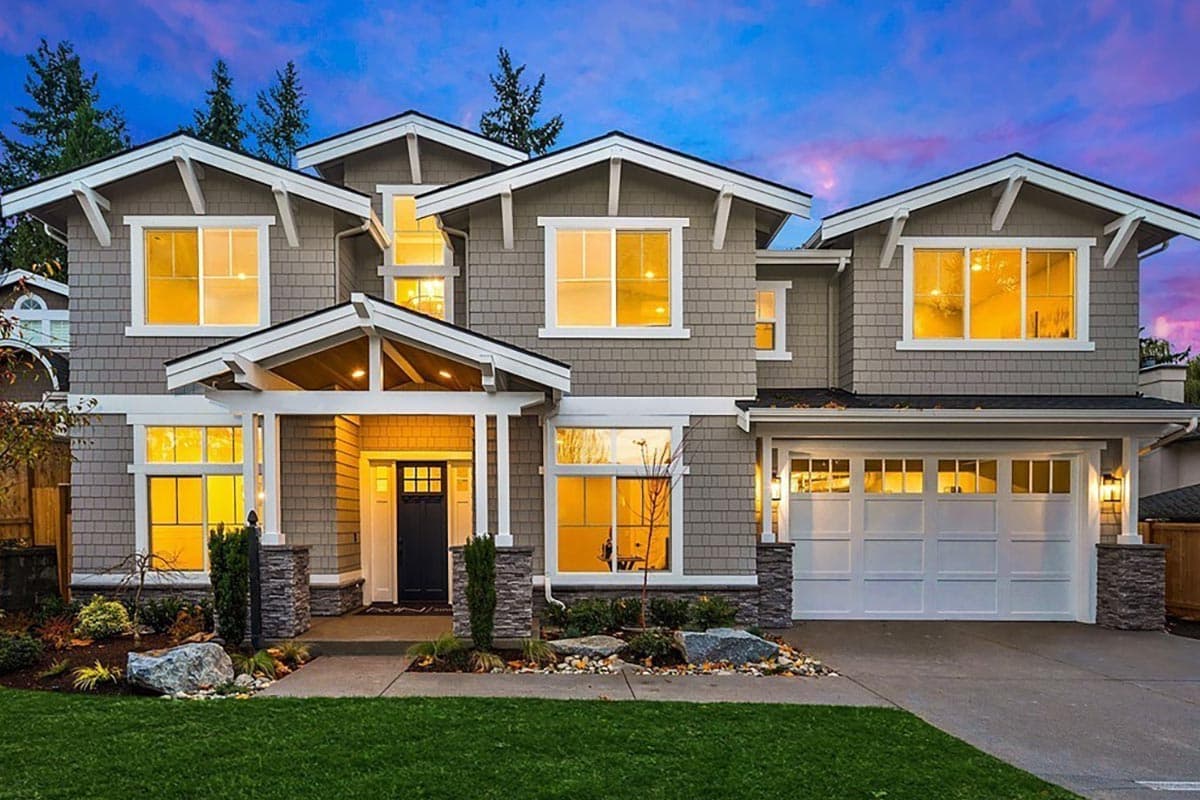 House plan exterior. Two-story Craftsman home with gabled rooflines, a front porch with exposed rafters, and a two-car garage.