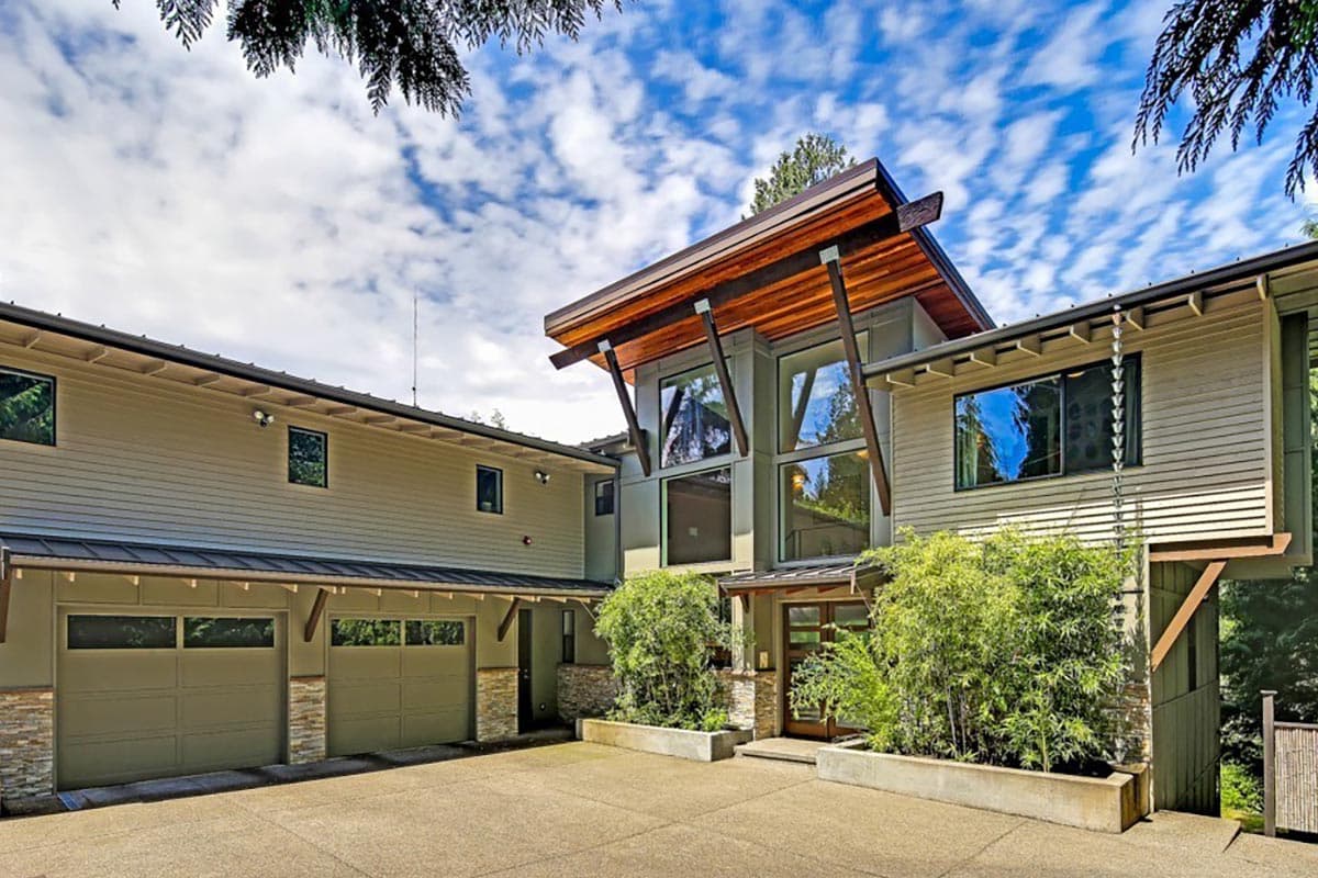 Modern house plan exterior with angled rooflines, extensive glazing, and a three-car garage.