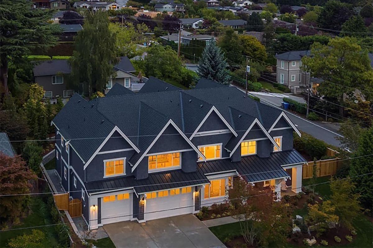 Two-story Modern Farmhouse exterior with multiple gables, a standing seam roof, and a three-car garage.