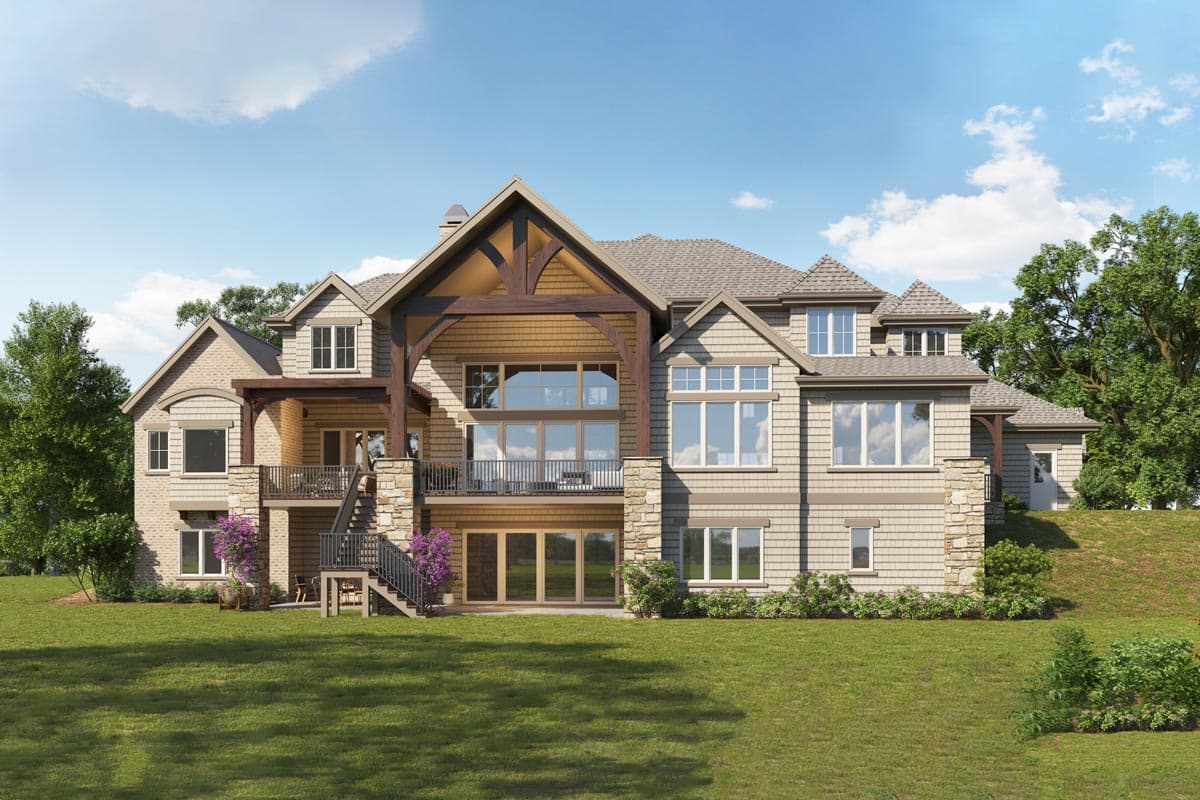 House plan exterior with multiple gables, large windows, stacked stone accents, and a timber-framed covered deck.