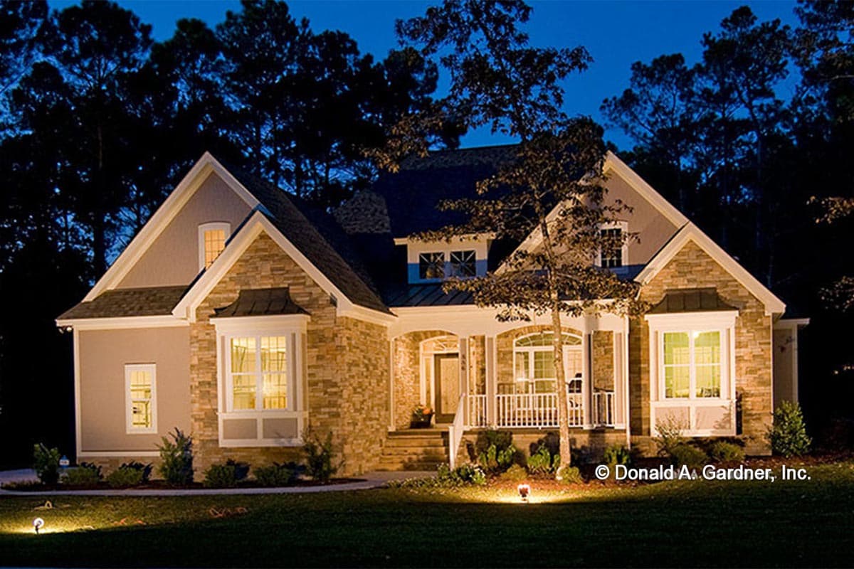 House plan exterior. One-and-a-half story home with stone accents, gable dormers, bay windows, and a covered front porch.