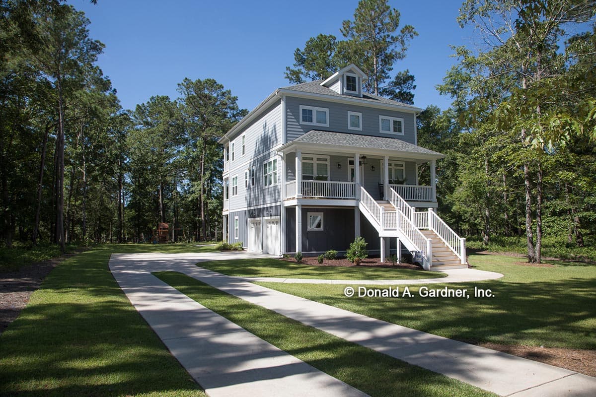 Three-story house plan exterior with a covered porch, dormer, and two-car garage.