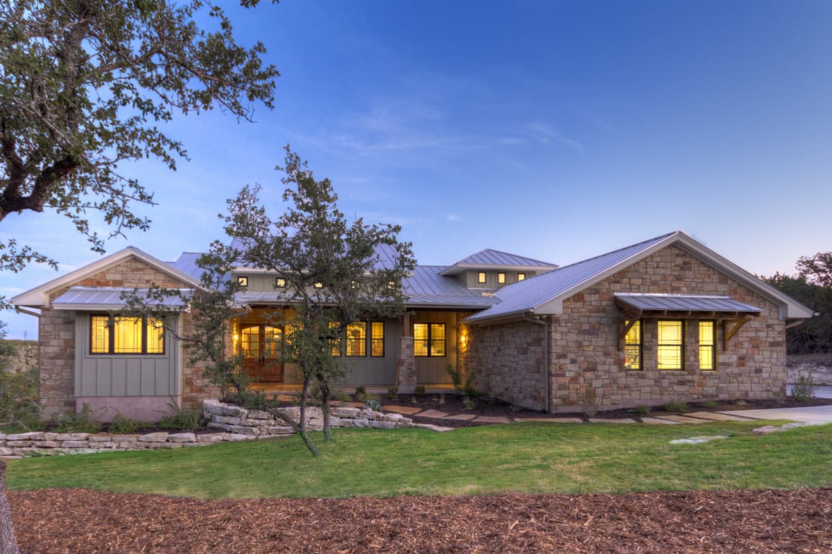 House plan exterior with stone veneer, metal roof, and gabled rooflines. Features include multiple dormers and a covered porch with supporting beams.