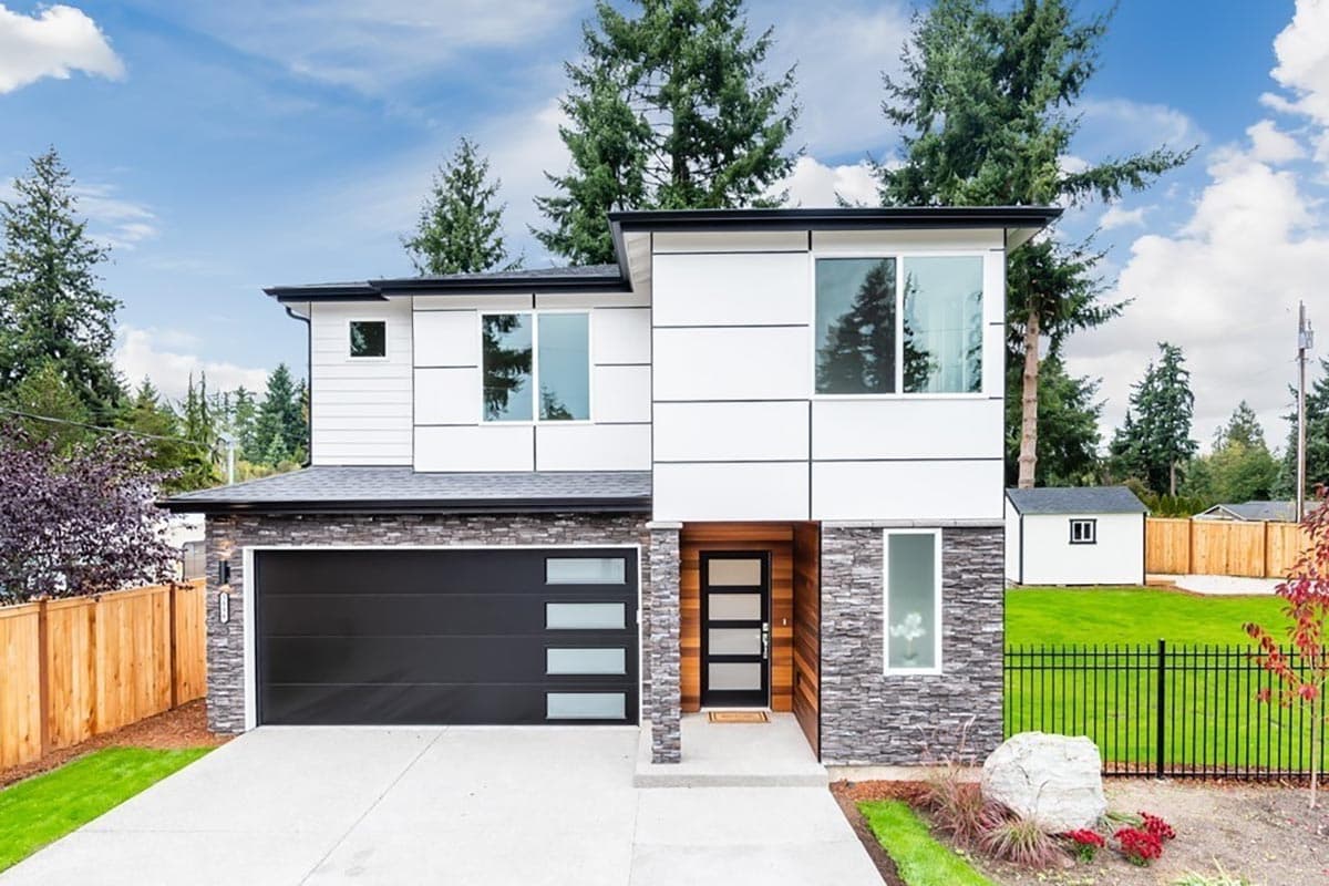 Modern house plan exterior with white siding, stone accents, large windows, and a multi-pane glass door.