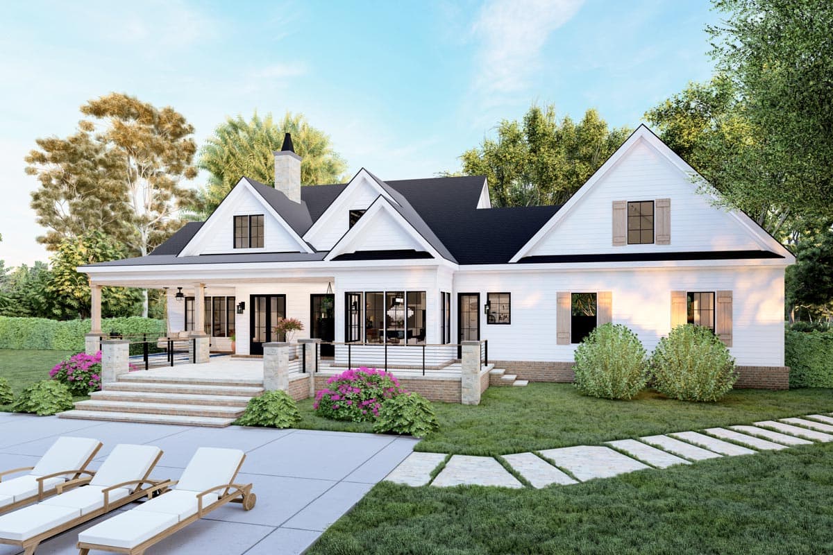 Modern Farmhouse house plan exterior with a wraparound porch, gables, and stone chimney. Two stories visible.