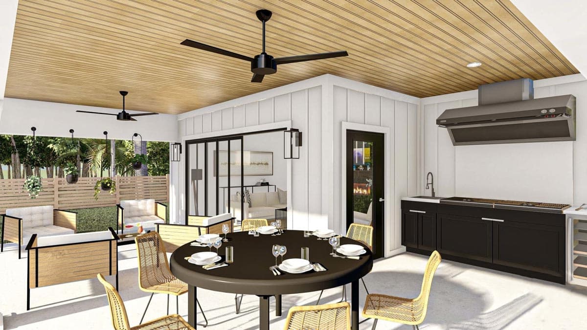 Outdoor living area with dining table, seating, and outdoor kitchen featuring grill and sink.