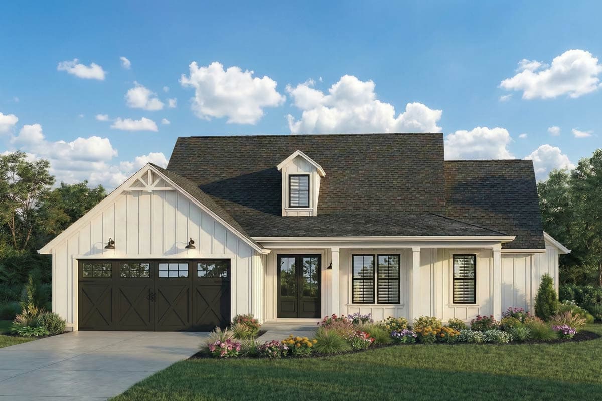 A white farmhouse with a dark grey roof and garage door. Colorful flowers line the front of the house, and a blue sky with clouds fills the background.