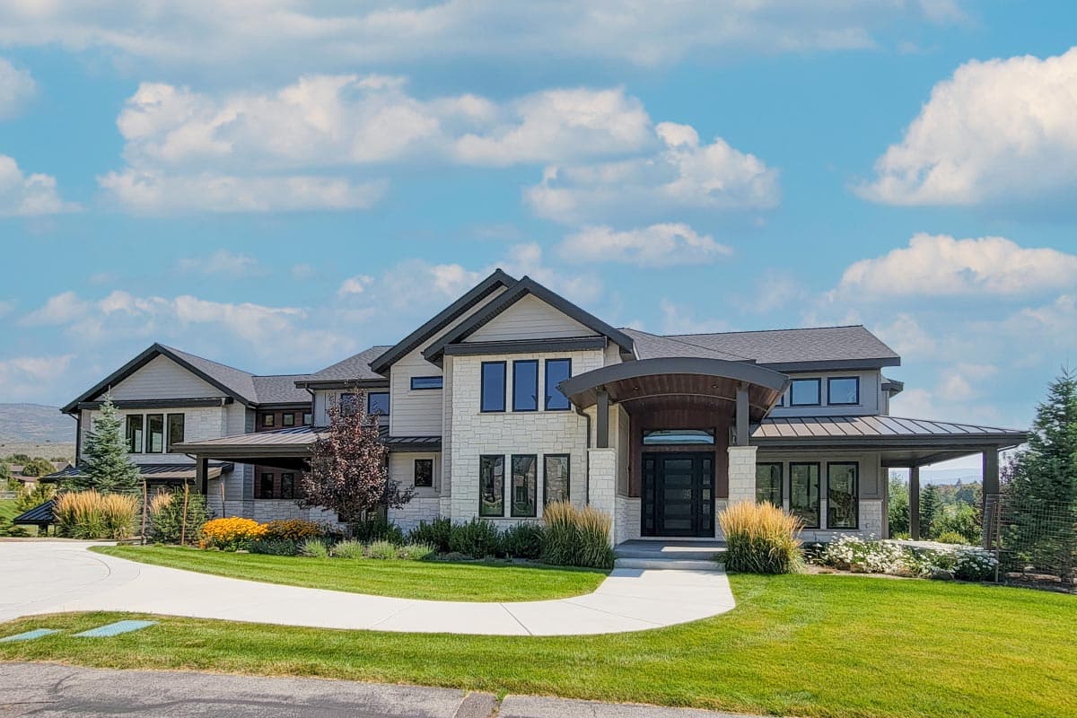 Two-story house plan exterior featuring a modern design, porte-cochere entry, gabled roof, and multiple covered porches.