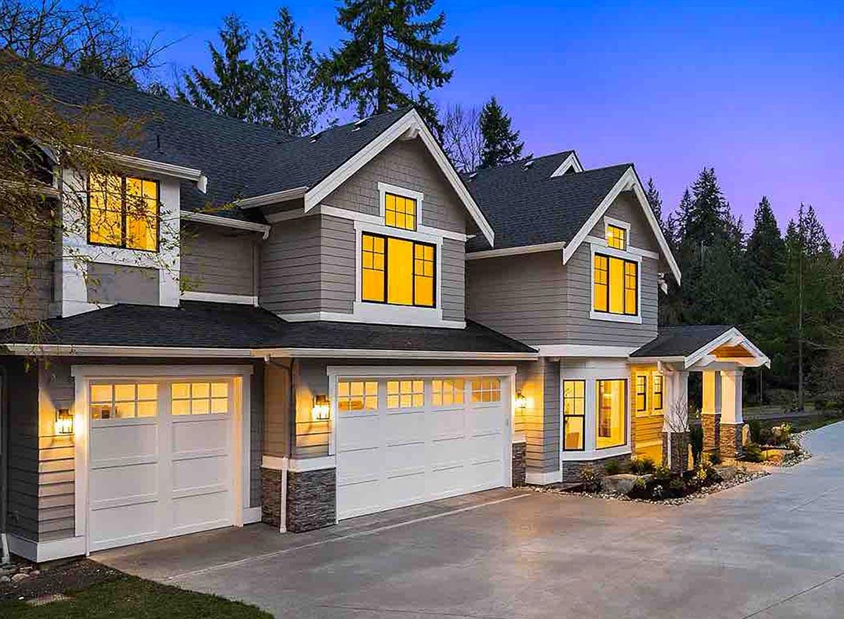 House plan exterior with dark roof, gray siding, multiple gables, and a three-car garage.