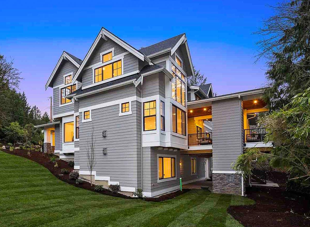 Modern house plan exterior with multiple gables, a connector bridge, and extensive window walls.
