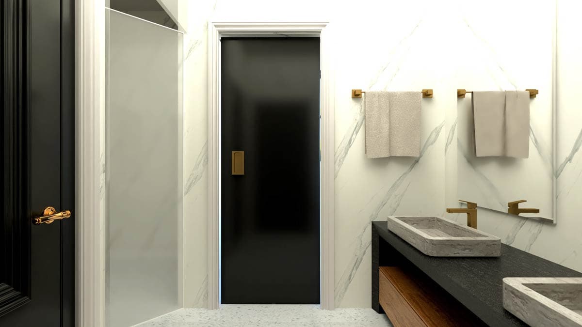 Bathroom with marble walls, black door, frosted glass shower enclosure, and stone vessel sinks with gold fixtures.