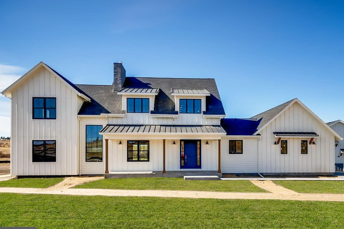 House plan exterior. Two-story Modern Farmhouse with gabled roof, dormers, and front porch. White siding and black window frames.