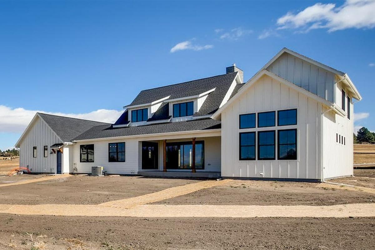 Modern Farmhouse house plan exterior with board and batten siding, dormer windows, covered porch, and large grid windows.
