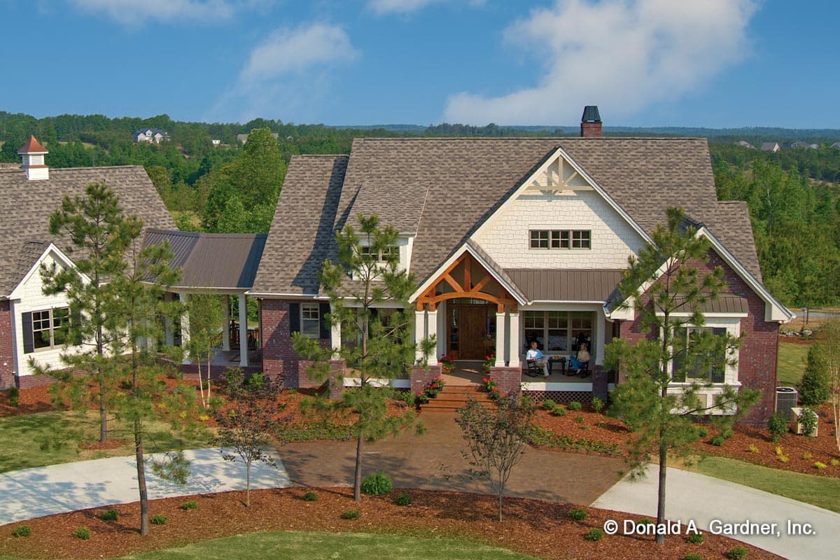 House plan exterior featuring Craftsman style, two stories, front porch, gables, and a brick and siding facade.