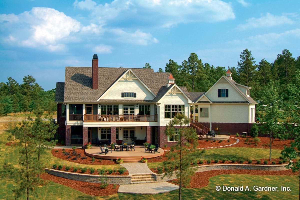 House plan exterior: A two-story, Shingle-style home with multiple gables, a wrap-around porch, and a rear deck.