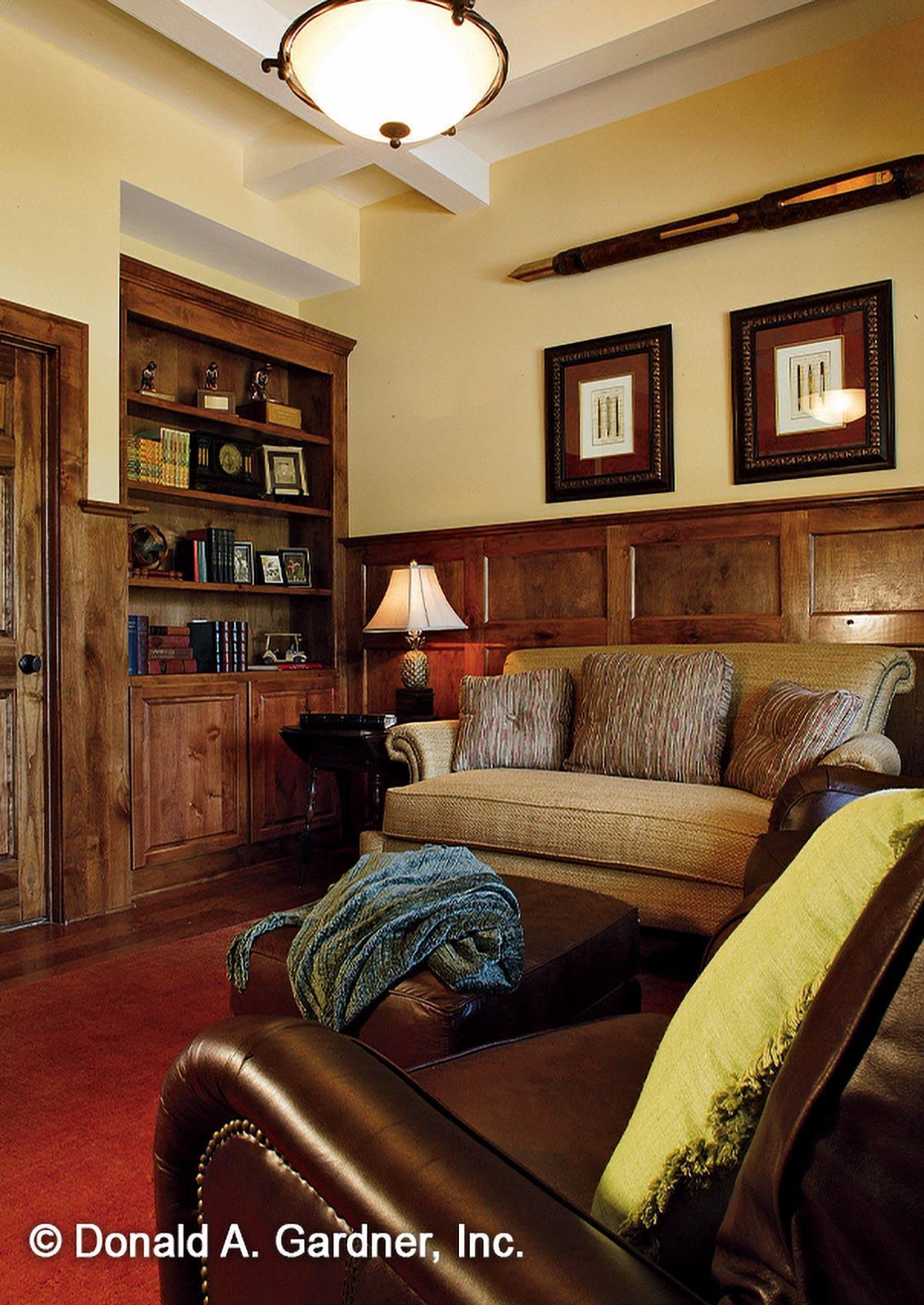 Study with built-in bookshelves, paneled walls, coffered ceiling, and upholstered sofa.