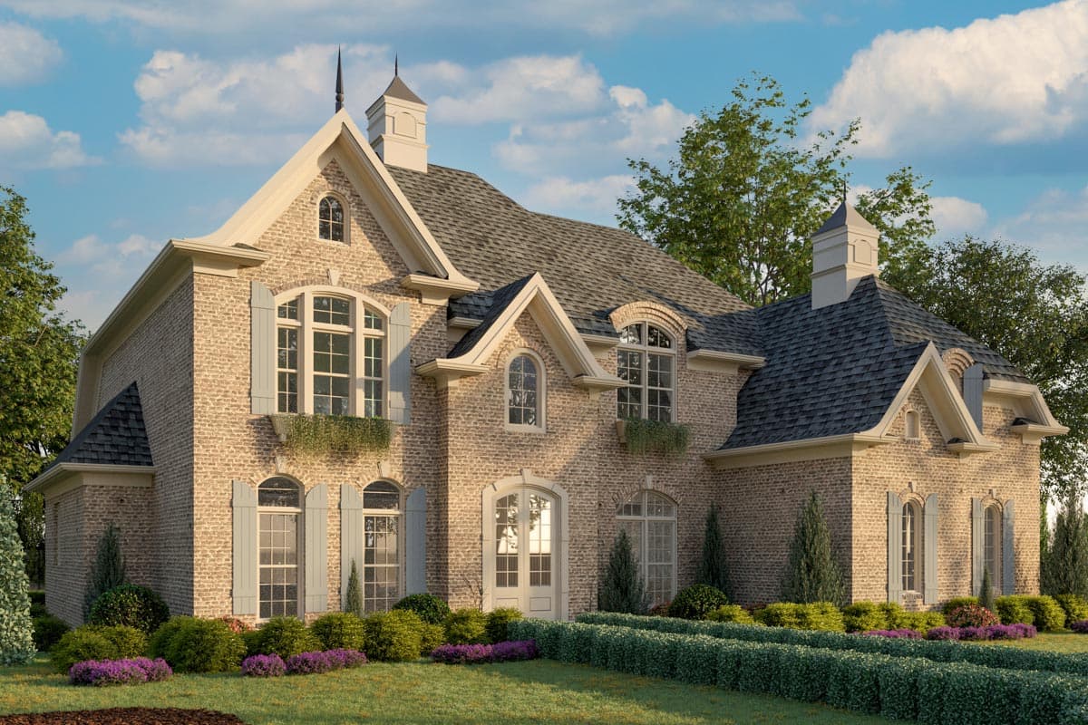 House plan exterior: Brick two-story home with steeply pitched roof, dormers, arched windows, and decorative gables.