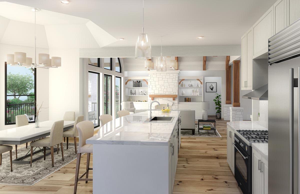 Modern open-concept kitchen and great room with large island, stone fireplace, vaulted ceiling, and dining area.