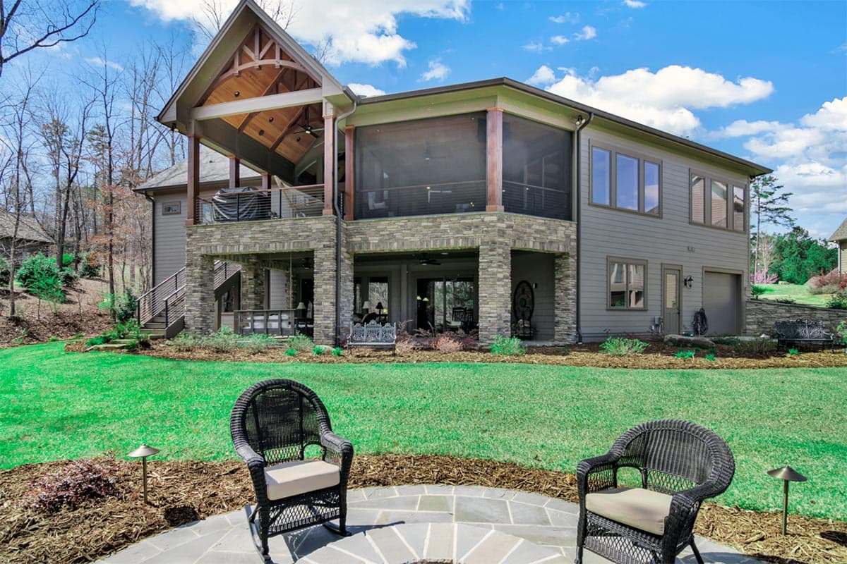 House plan exterior with a covered gable porch, stone-clad base, multiple levels, and screened porch.