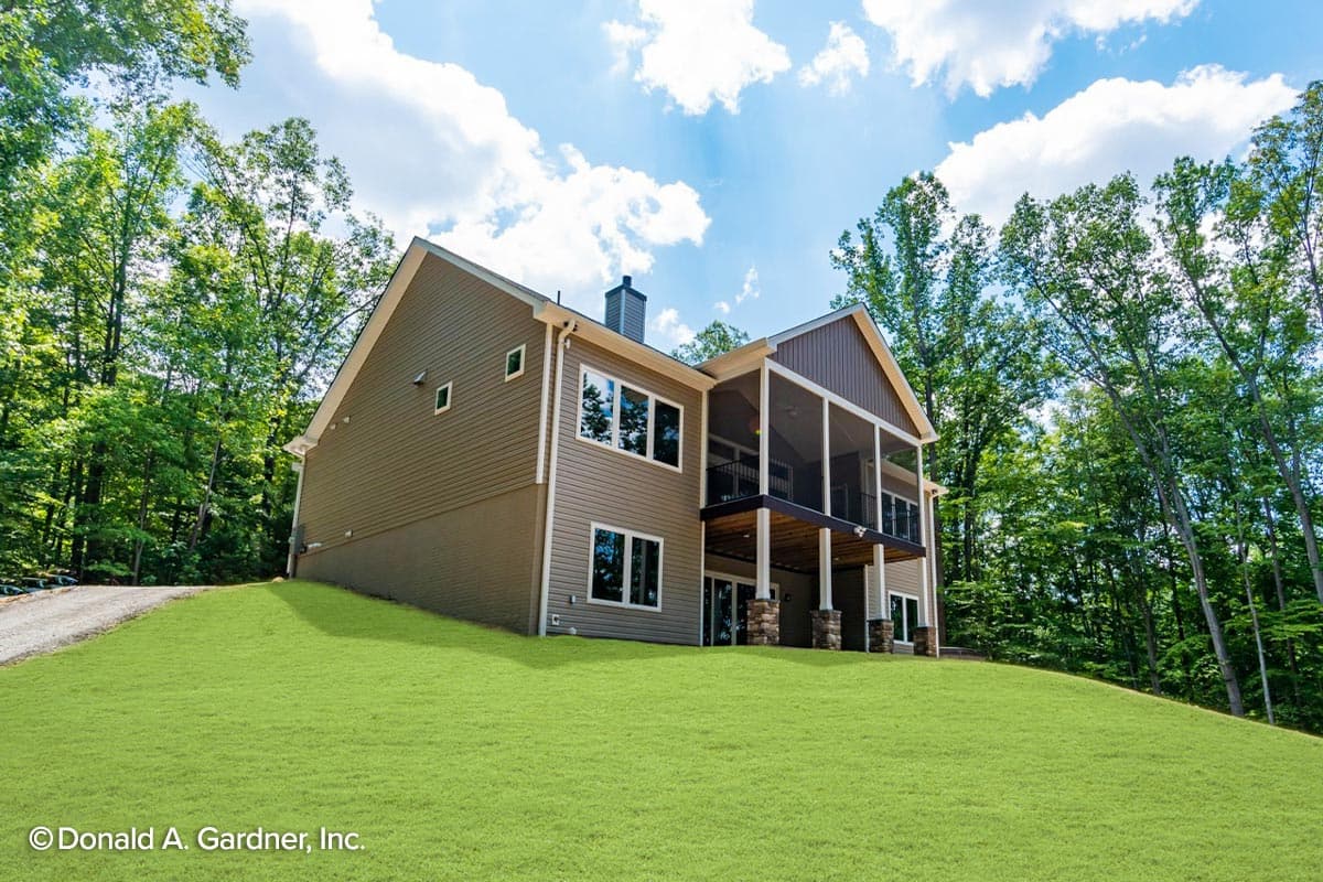 House plan exterior: Two-story home with a screened-in upper porch, stone-clad supports, and large windows.