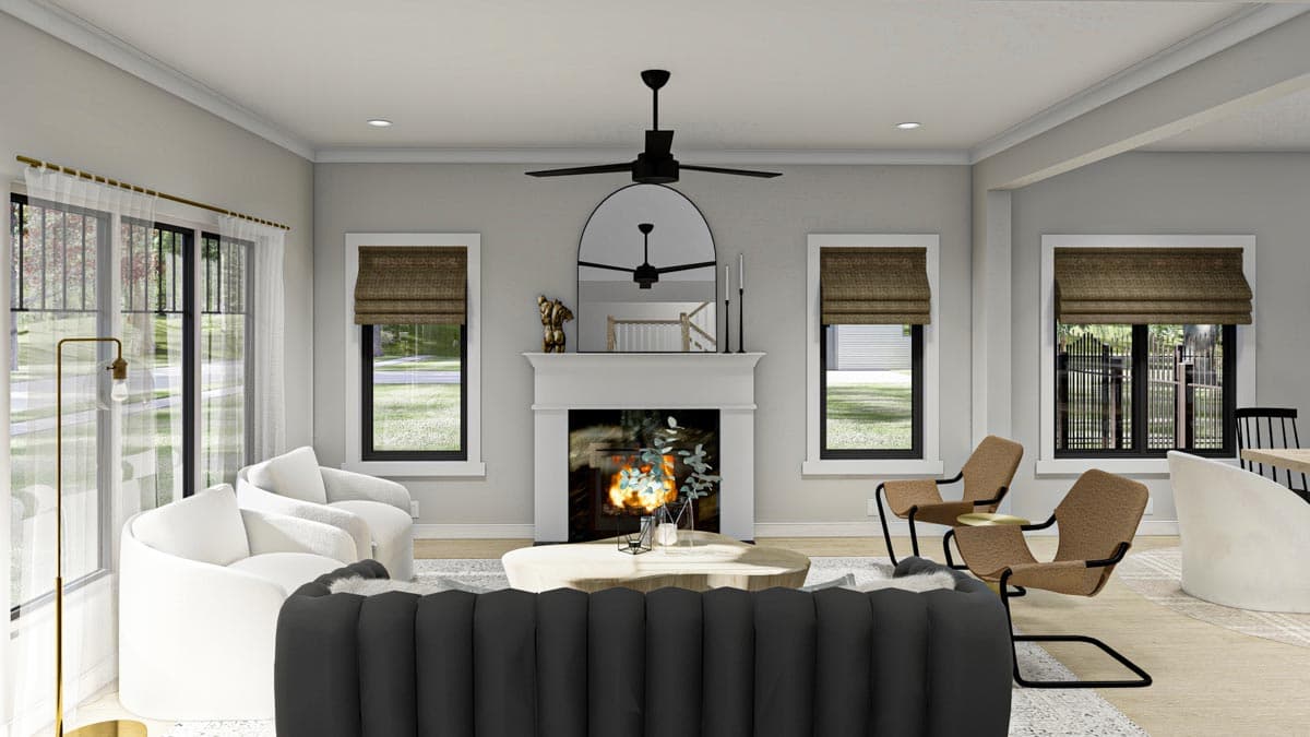 Living room interior featuring a fireplace, seating area with white chairs and a black sofa, and large windows.