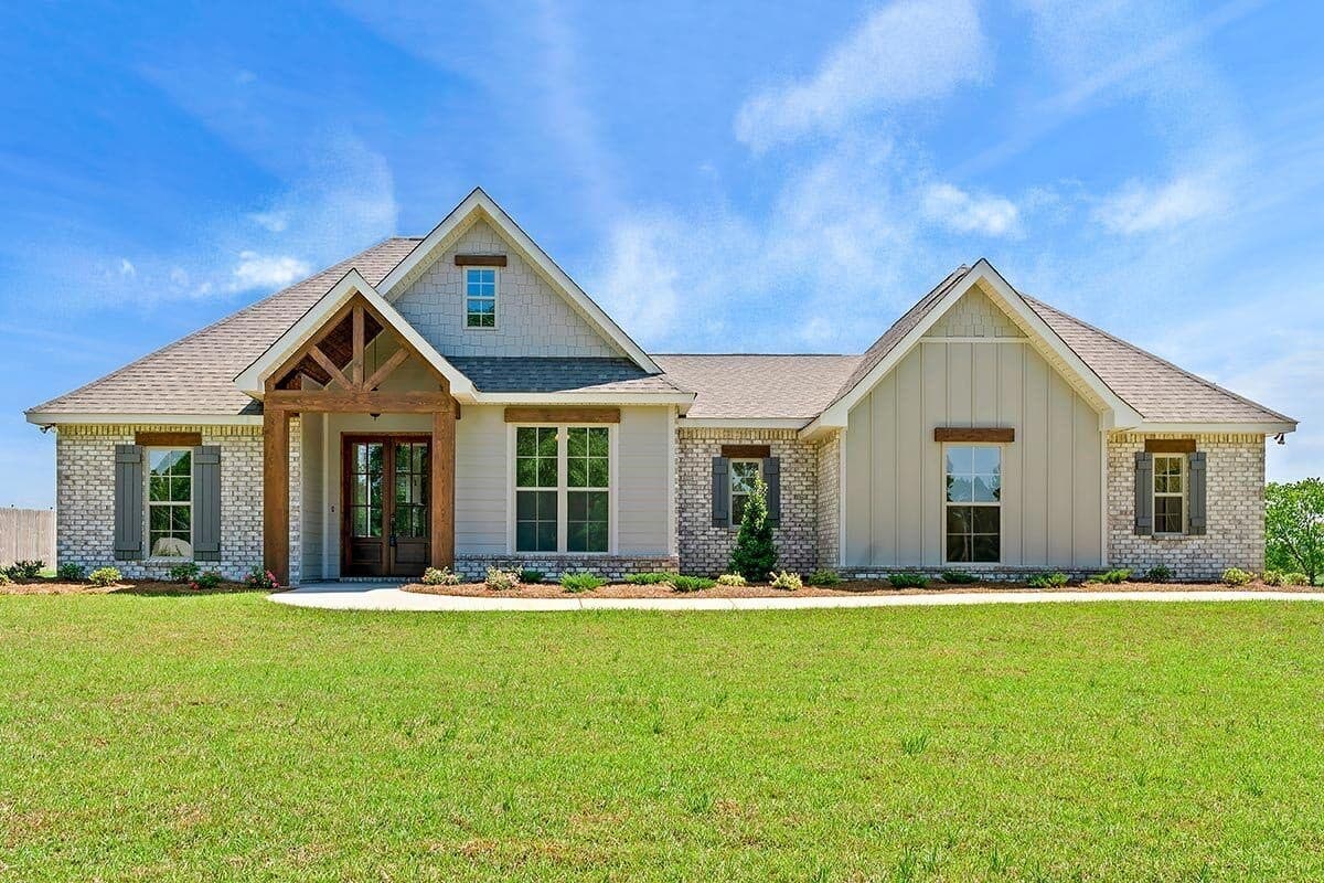 House plan exterior. One-story Ranch style home with gabled rooflines, a front porch with exposed timber supports, and brick accents.