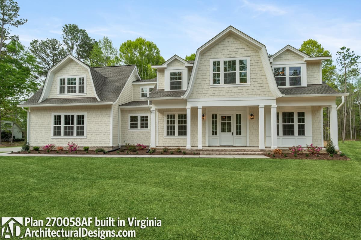 House plan exterior: Two-story home with gambrel dormer, gables, and covered front porch with columns.