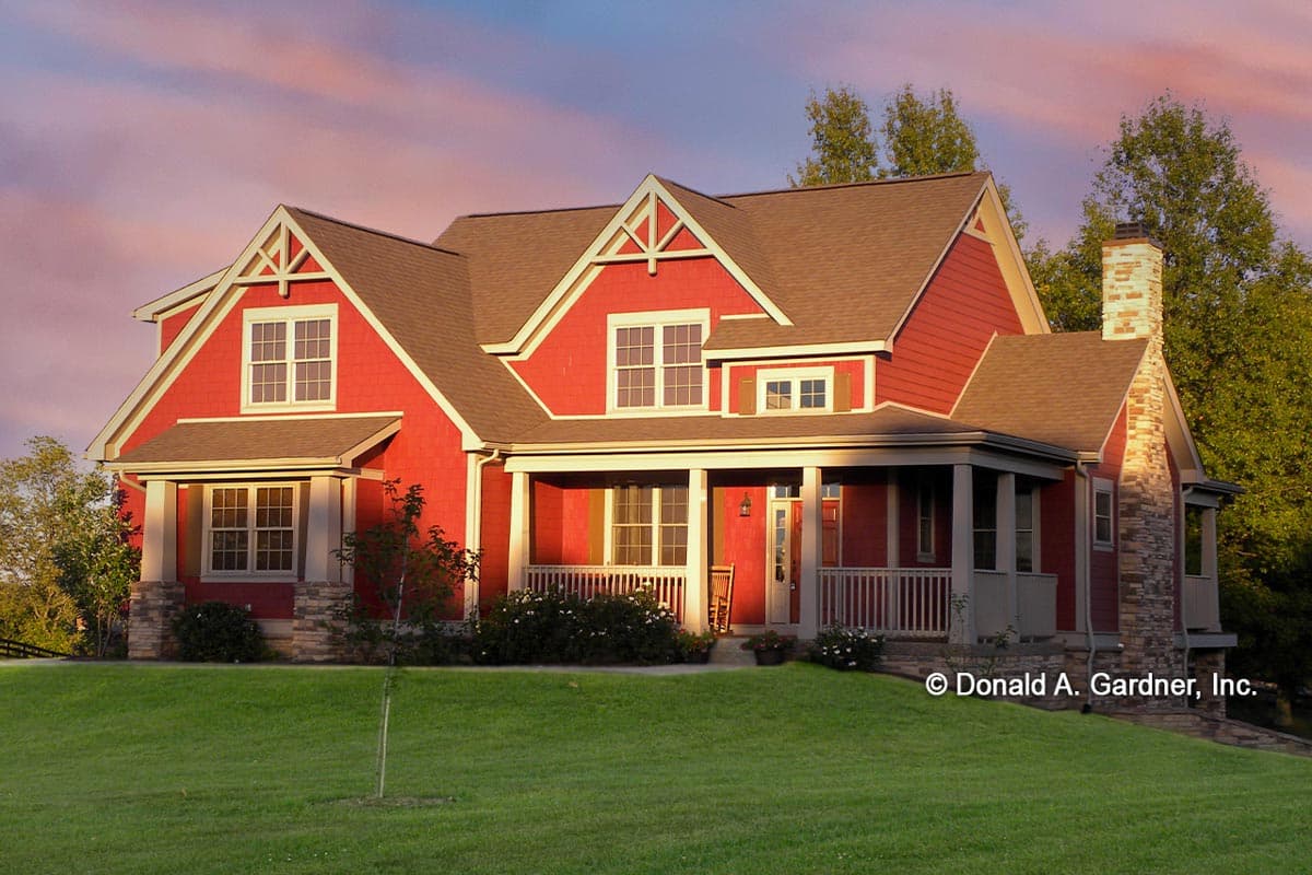 House plan exterior. Two-story Craftsman home with a front porch, gables, and a stone chimney. Red siding, brown roof, and white trim.