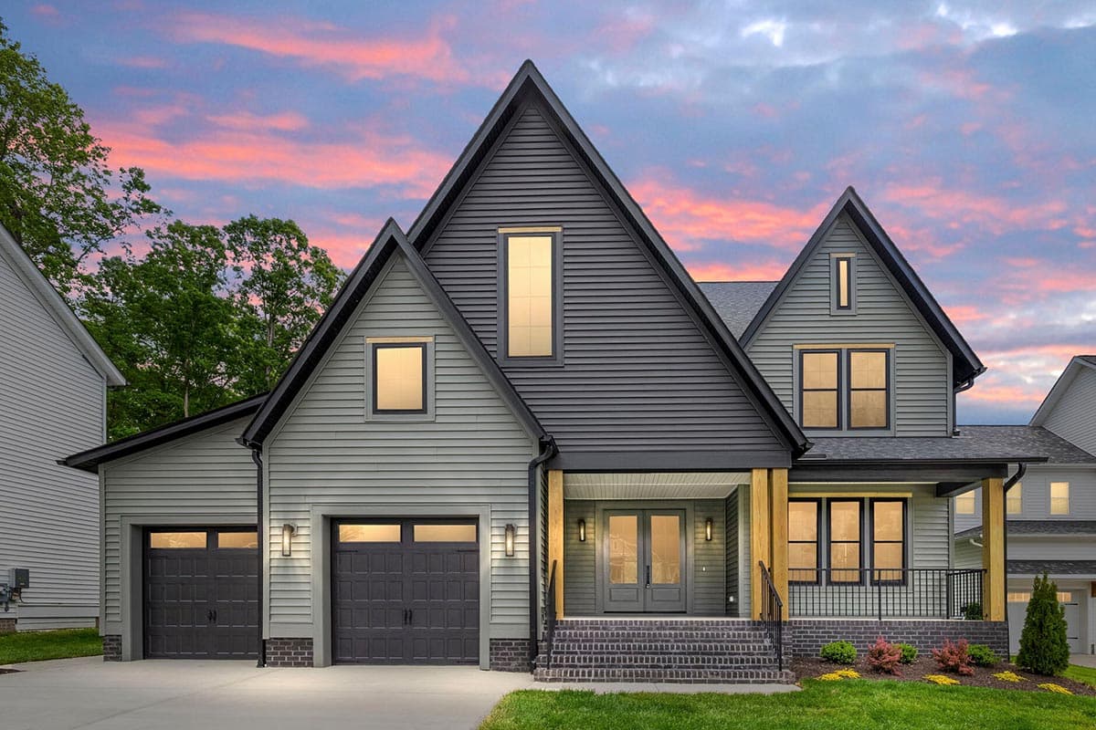 House plan exterior. Two-story Modern Farmhouse with gables, front porch, and garage. Features include board and batten siding and multiple windows.