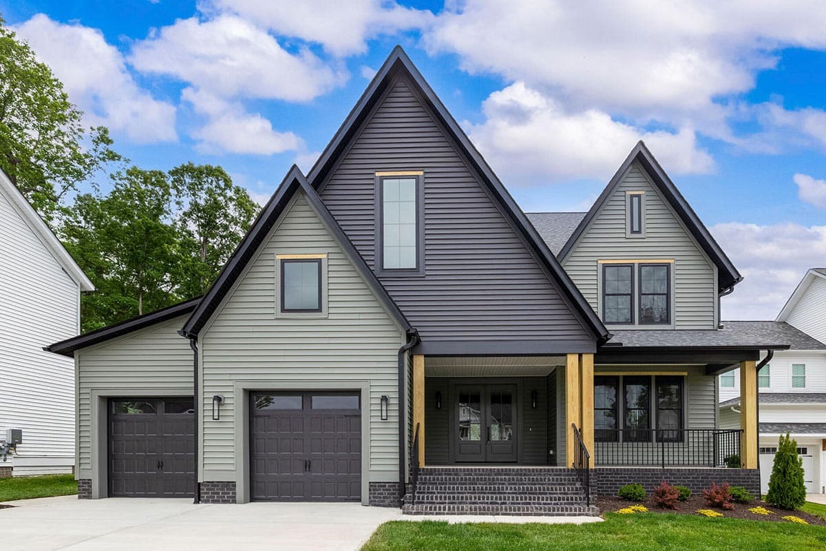 Modern Farmhouse style house plan exterior with two garages, covered porch with wood posts, and multiple gables.