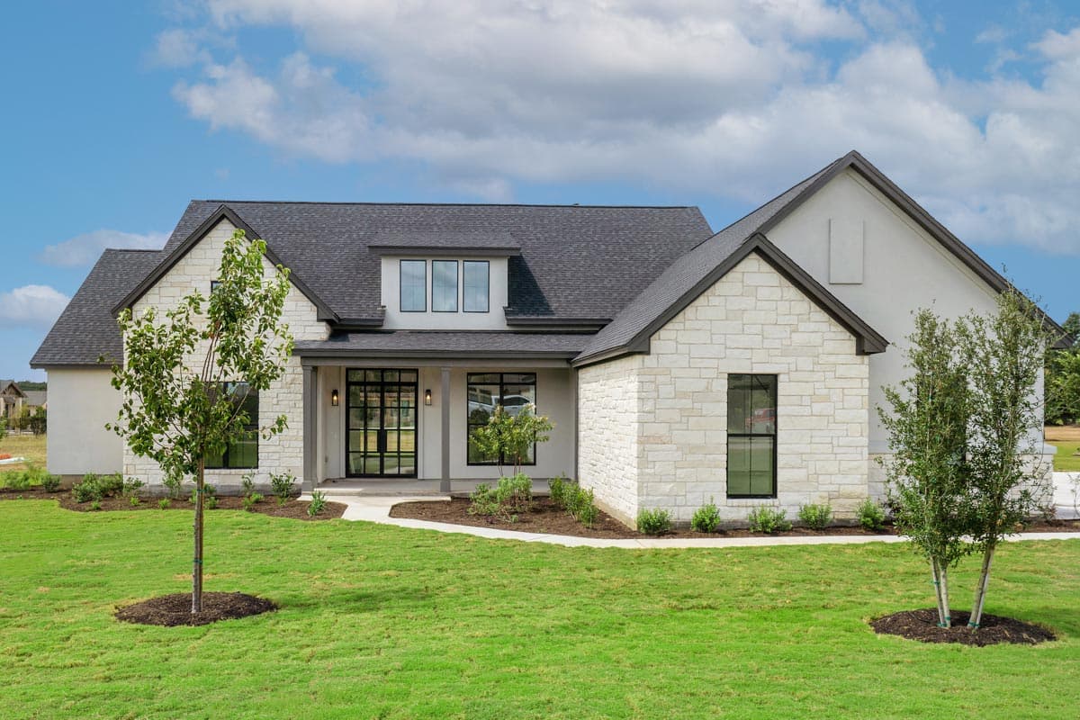 Modern Farmhouse house plan exterior with stone accents, dark roof, and metal-framed double doors on a covered porch.