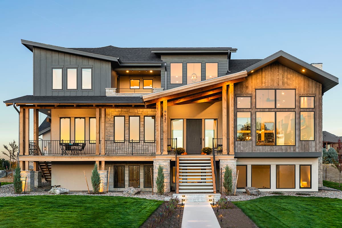House plan exterior. Two-story modern home with a covered porch, wood-clad gable, and mixed siding materials.