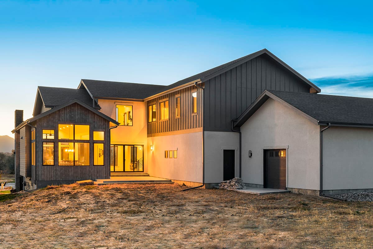 Modern two-story house plan exterior with multiple gables, large windows, wood siding accents, and attached garage.