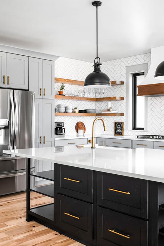 Kitchen featuring a center island, stainless steel refrigerator, gray cabinetry, wood shelves, and herringbone tile backsplash.