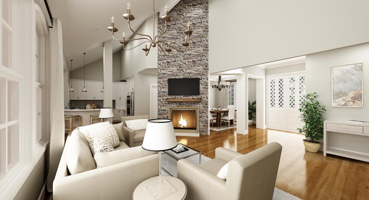 Great room with vaulted ceiling, stone fireplace, television, and open kitchen. Dining area visible.