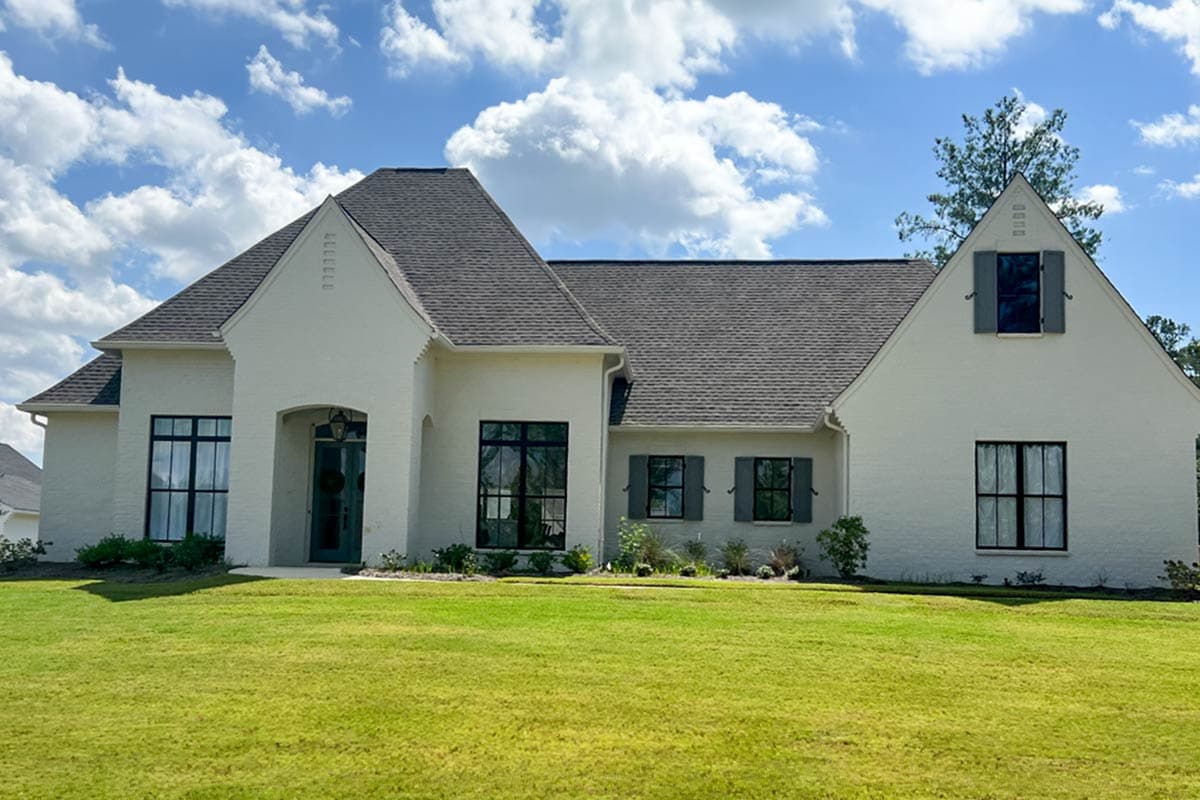 House plan exterior of a two-story modern home with a stucco finish, prominent gables, and dark-framed windows.