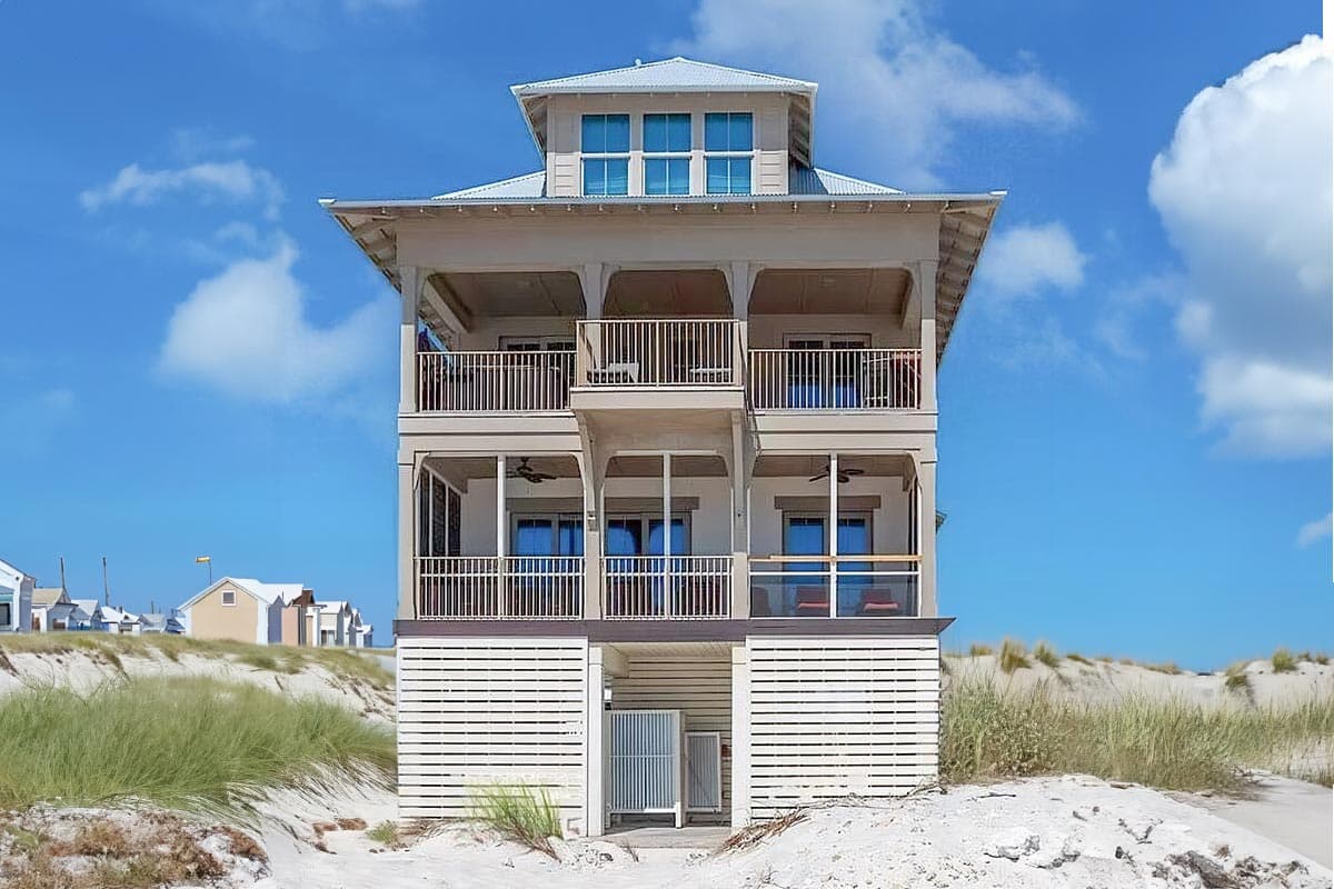 House plan exterior. Two-story beach house with balconies, a raised foundation, and a central cupola with multiple windows.