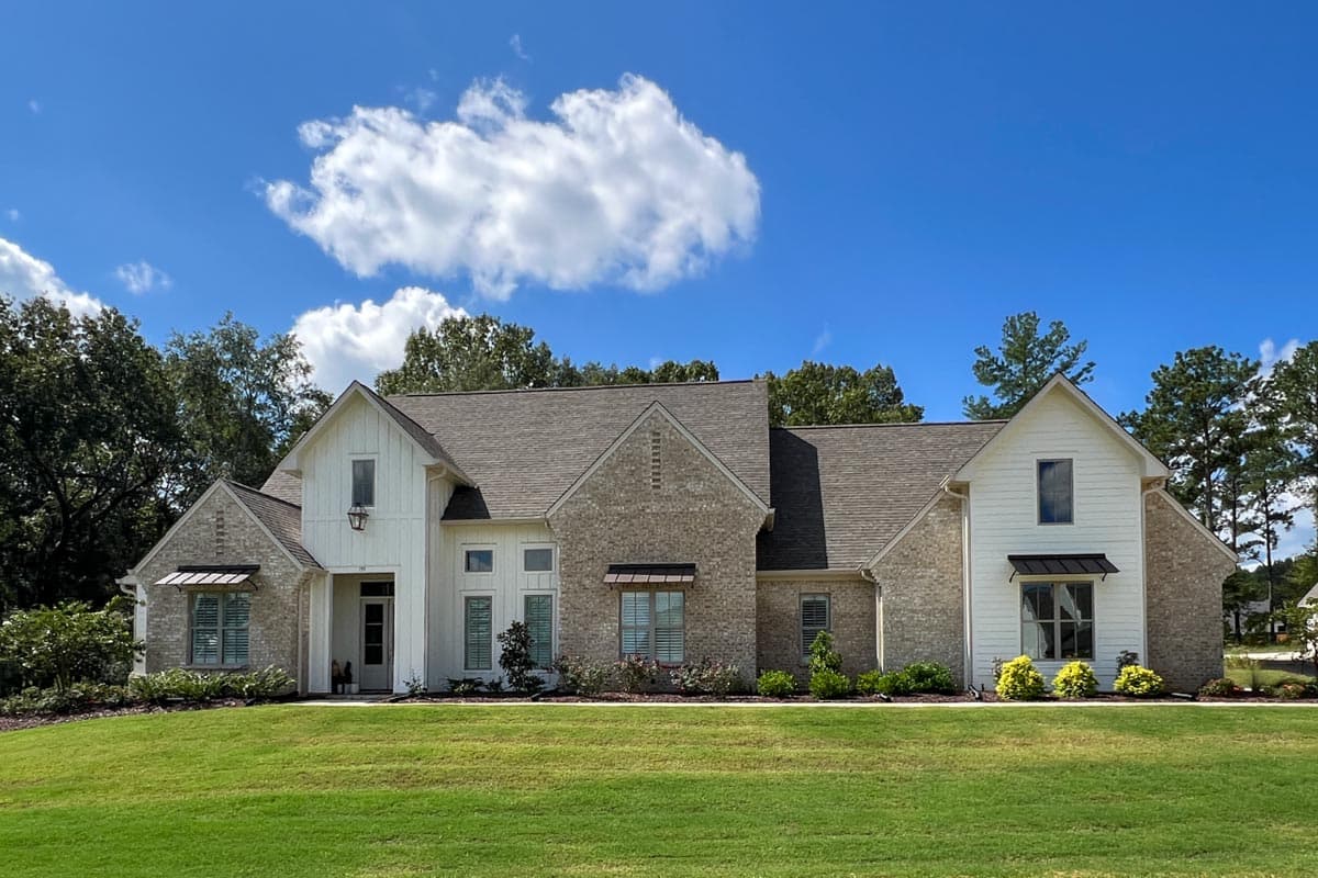 House plan exterior: Modern Farmhouse style, two stories, brick and board-and-batten siding, gable roofs, and prominent dormers.