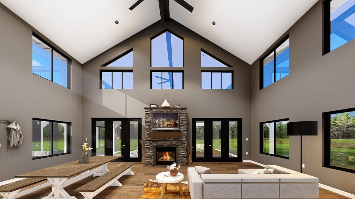 Great room with vaulted ceiling, stone fireplace, large windows, and dining area.
