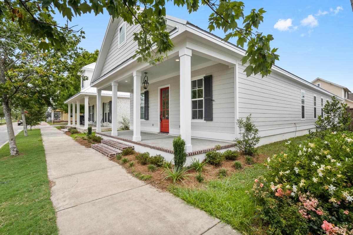 House plan exterior with a front porch supported by square columns, gable roof, and horizontal siding.