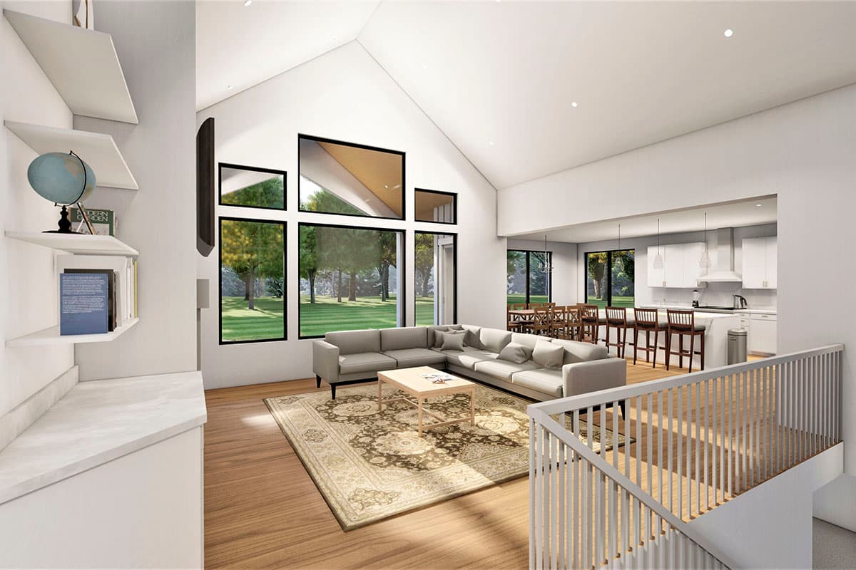 Open concept living area with vaulted ceiling, large sectional, fireplace, and kitchen with island and bar seating.